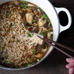 easy homemade ramen in a Dutch oven with chopsticks lifting the noodles