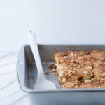 white serving spatula in baking pan with cinnamon streusel coffee cake