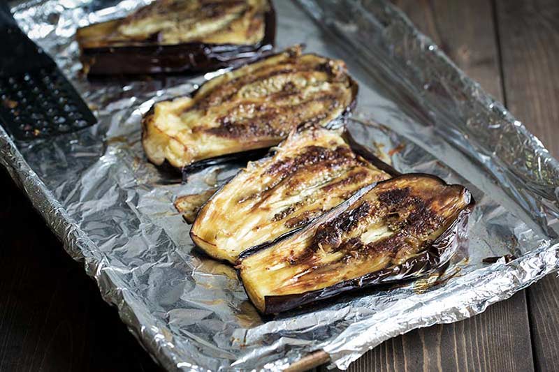 Roasted eggplant in a pan, flipped over to show pulp side