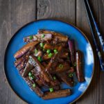 Chinese eggplant recipe on a blue dish with chopsticks