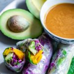 Vegetarian Summer Rolls next to peanut sauce and avocados