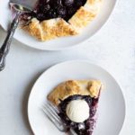 Overhead shot of full cherry galette and a single slice topped with ice cream