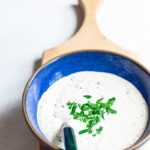 homemade horseradish sauce topped with chopped parsley in blue bowl