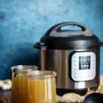 Chicken stock in two large mason jars in front of an Instant Pot pressure cooker