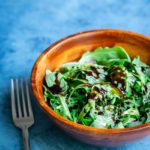Balsamic reduction recipe drizzled over arugula with fork