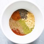Closeup of a bowl with unblended spices for homemade old bay seasoning