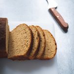 Sliced oatmeal molasses bread on a cutting board
