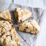Chocolate chip scones on a round cooling rack and napkin